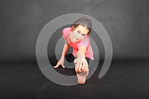 Pretty girl exercising stretching and holding her toes