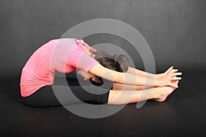 Pretty girl exercising yoga - seated forward fold