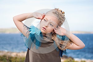 Pretty girl in a fairy makeup stretches after a nap on the beach