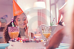 Pretty girl feeling excited while looking at the marvelous cake