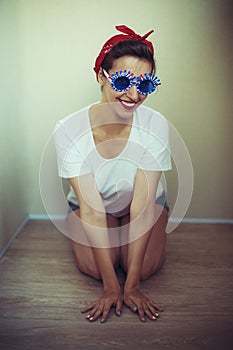 Pretty girl in funny sunglasses, dressed in a pin-up style