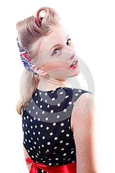 Pretty girl funny young blond pinup woman in polka dot dress with curlers looking at camera shoulders back isolated on white