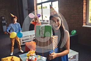 Pretty girl in a hat holding presents and looking excited