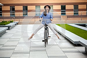 Pretty girl in hat riding a bicycle at street