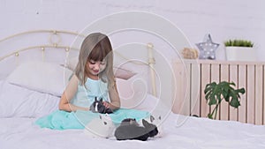 Pretty girl having fun, hugging and playing with decorative rabbit