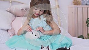 Pretty girl having fun, hugging and playing with decorative rabbit