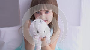 Pretty girl having fun, hugging and playing with decorative rabbit