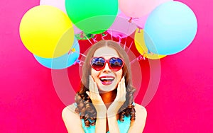 Pretty girl is having fun over an air colorful balloons pink