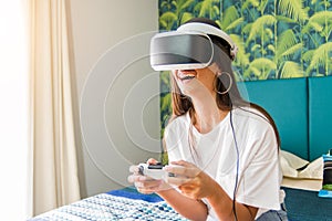 Pretty girl having fun playing videogames with virtual reality device. photo