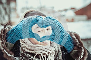 Pretty girl with heart shaped hands in the gloves