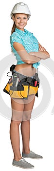 Pretty girl in helmet, shorts, shirt and tool belt