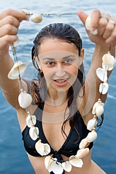 Pretty girl holding seashell beads
