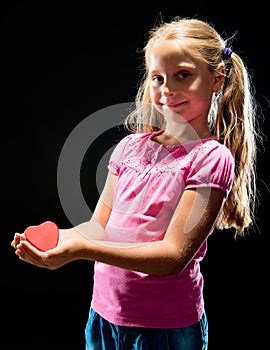 Pretty girl holding small heart symbol