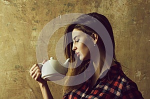 Pretty girl holding white ceramic tea pot