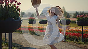 Pretty girl jumping with lightness and elegance in spring flower garden outside.