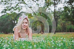 Pretty girl laying on the grass in spring park and smiling