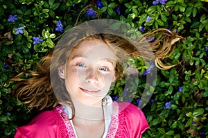 Pretty girl laying in periwinkle plant