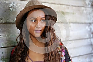 Pretty girl leaning against a wood wall