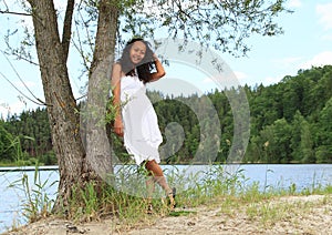 Pretty girl leaning on tree by Dam Rimov