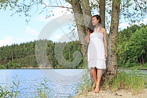 Pretty girl leaning on tree by Dam Rimov