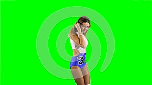 Pretty girl listens music in headphones at green background