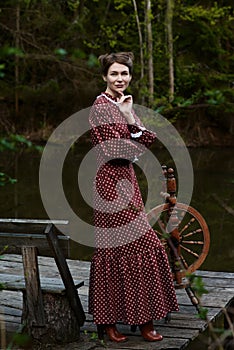 Pretty girl in long dress at the deep dark forest