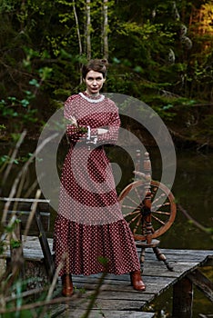 Pretty girl in long dress at the deep dark forest