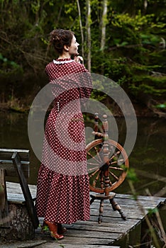 Pretty girl in long dress at the deep dark forest