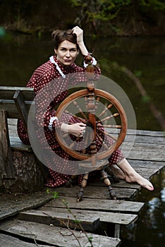 Pretty girl in long dress at the deep dark forest