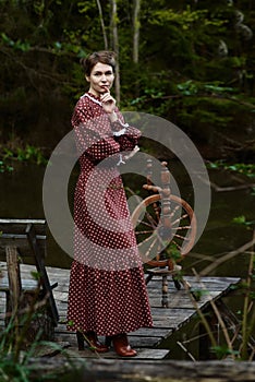 Pretty girl in long dress at the deep dark forest