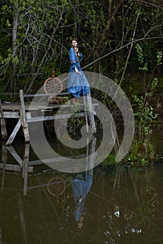 Pretty girl in long dress at the deep dark forest