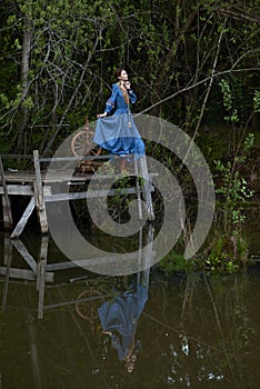 Pretty girl in long dress at the deep dark forest