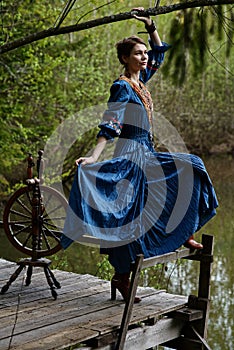 Pretty girl in long dress at the deep dark forest