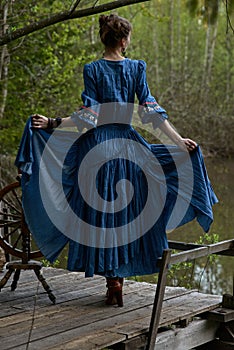 Pretty girl in long dress at the deep dark forest