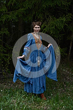 Pretty girl in long dress at the deep dark forest