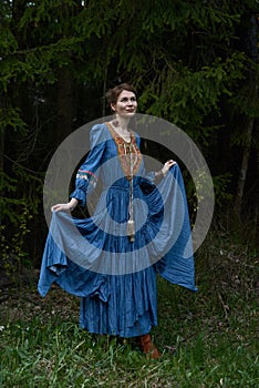 Pretty girl in long dress at the deep dark forest