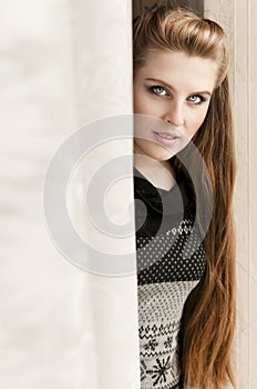Pretty Woman peeping from behind the curtain
