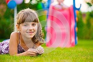 Pretty girl lying on grass at playground