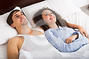Pretty girl lying near boyfriend and smiling