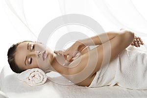 Pretty girl lying on a table with towel and hand o