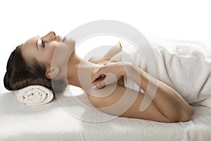 Pretty girl lying on a table with towel in profile