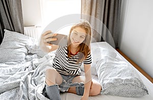 Pretty girl making selfie in bed