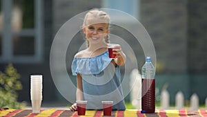 Pretty girl offering strawberry lemonade, selling beverage to earn pocket money