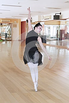 Pretty girl performs a pirouette in ballet class