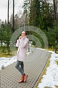 Girl in pink coat walking along pathway in forest