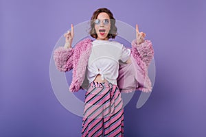 Pretty girl in pink striped pants posing in studio. Indoor shot of spectacular european woman in fu