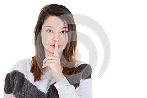 Pretty girl placing fingers on lips shhh sign symbol with copyspace blank white background