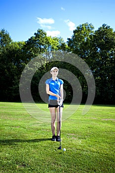 Pretty girl playing golf on field