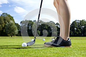 Pretty girl playing golf on grass