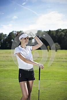 Pretty girl playing golf on grass